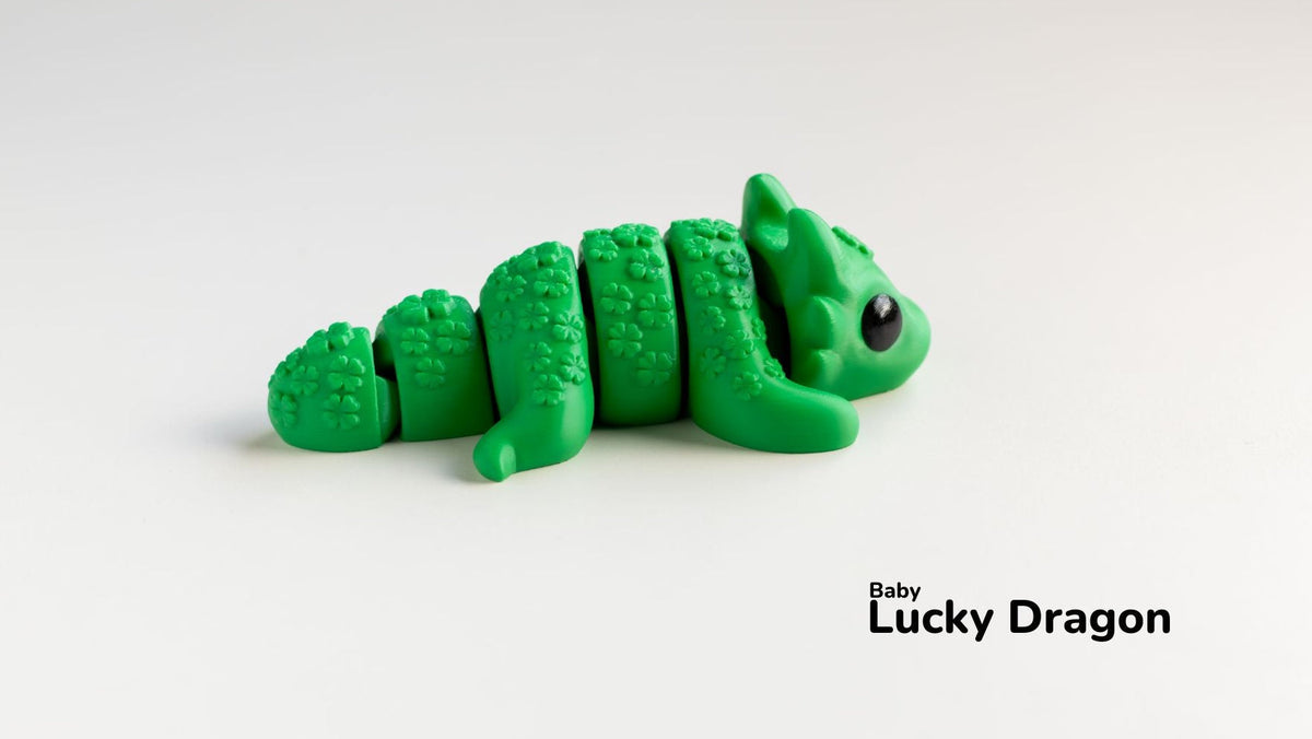 Green Baby Lucky Dragon lying on a white surface