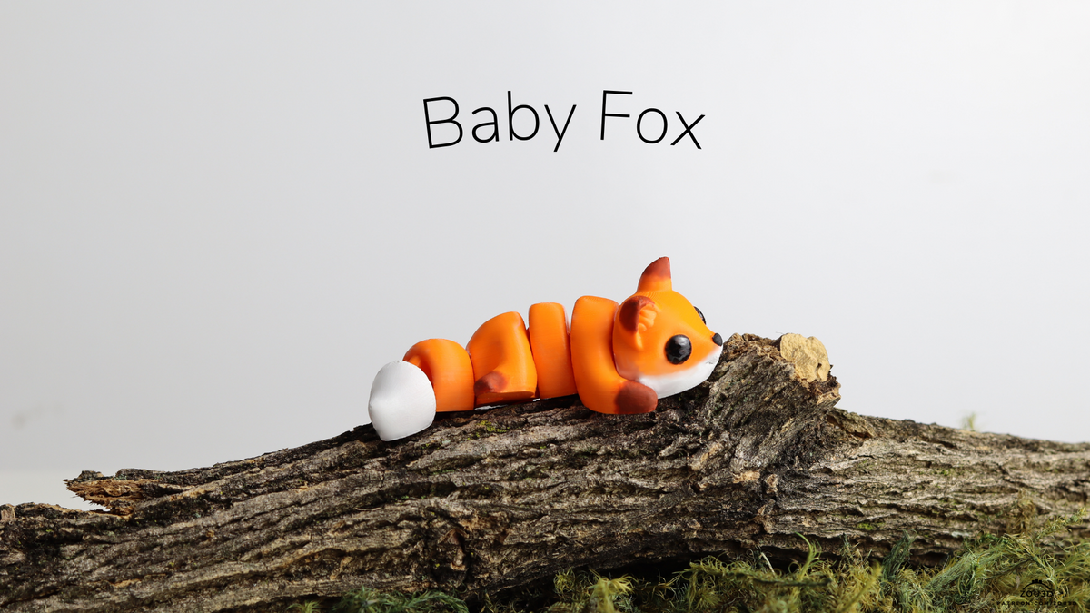 Orange and white Baby Fox lying on a log