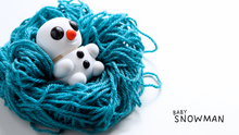 White Baby Snowman figures sitting in a blue yarn nest