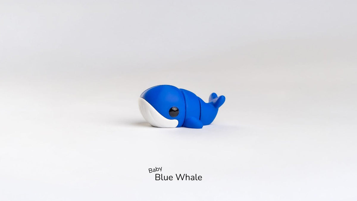 Blue and white whale toy on a light gray background