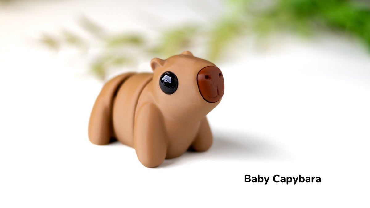 Toy baby capybara on a white background with blurred greenery