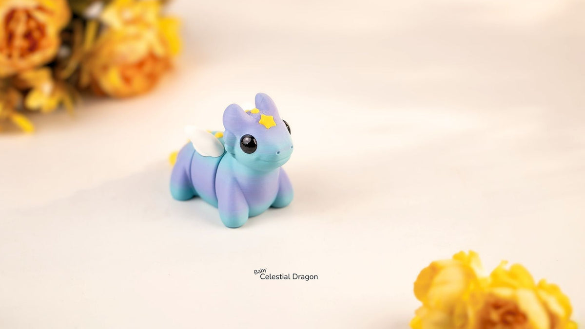 Small blue dragon figurine with yellow accents on a light background with yellow flowers.