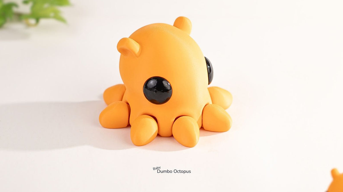 Orange octopus toy with black eyes on a white surface
