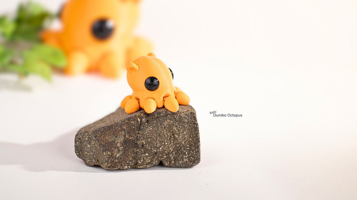 Small orange octopus figurine on a rock with a blurred background