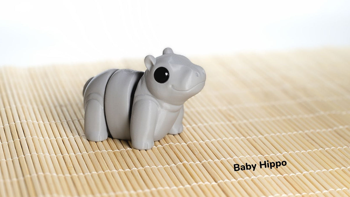 Gray hippo-shaped object on a bamboo mat with 'Baby Hippo' text