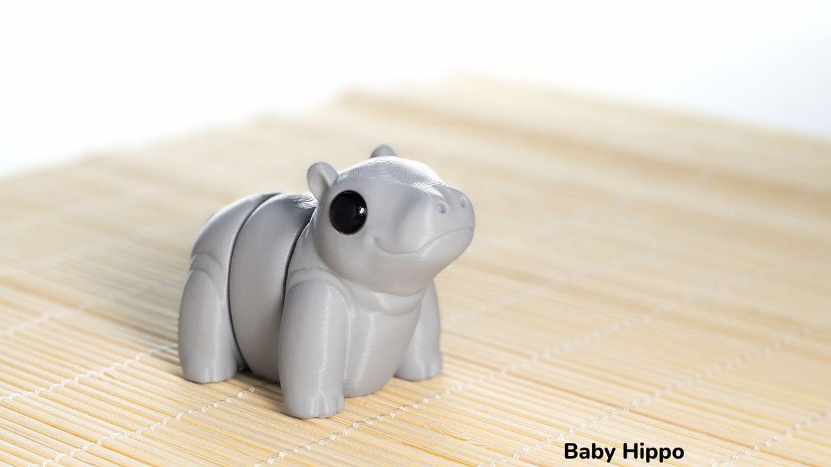 Gray hippo figurine on a textured surface with 'Baby Hippo' text