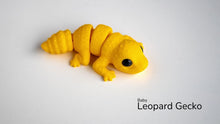 Yellow toy baby leopard gecko on a white background