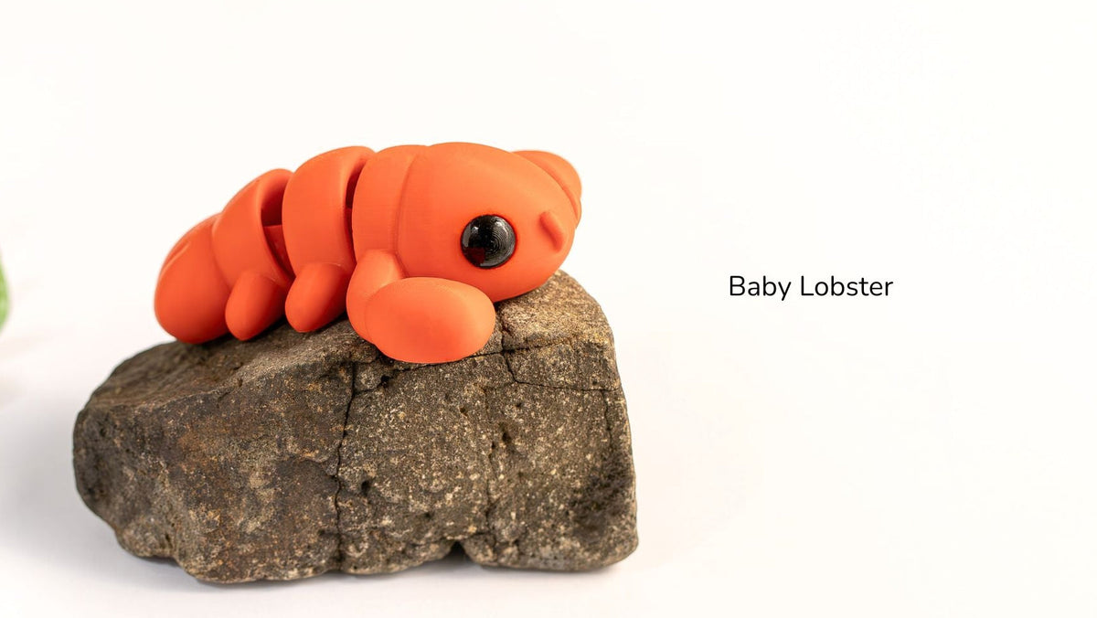 Model of a baby lobster on a rock with a white background