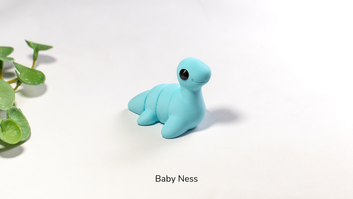 Blue toy seal on a white background with 'Baby Ness' text