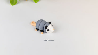 Grey Baby Opossum with white face, side view