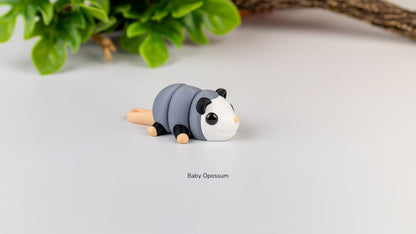 Baby Opossum fidget toy with greenery behind