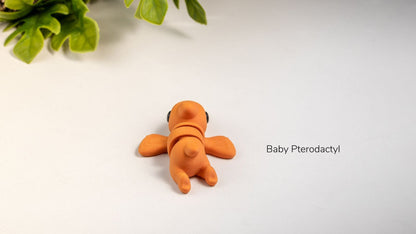 Small orange Baby Pterodactyl on a white surface