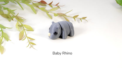 Model of a baby rhino on a white background with green leaves