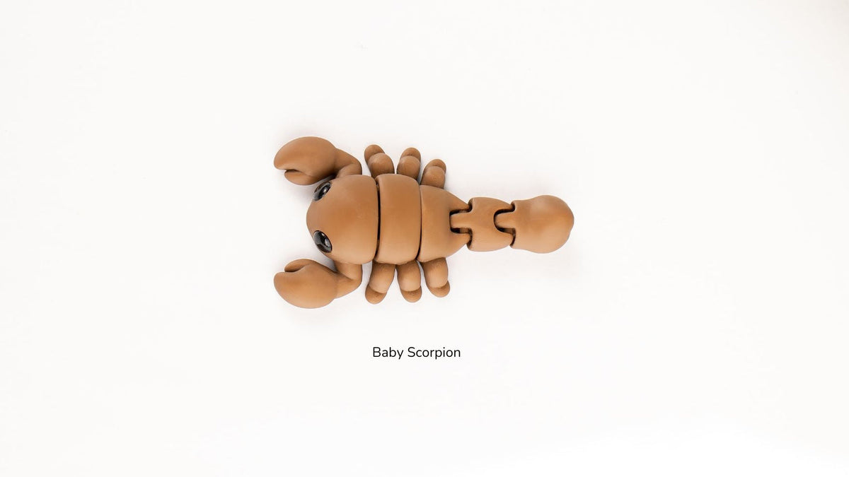 Articualted toy resembling a baby scorpion on a white background