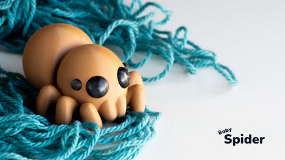 Toy spider on blue yarn with 'Baby Spider' text
