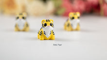Yellow and black Baby Tiger fidget toys with flowers behind