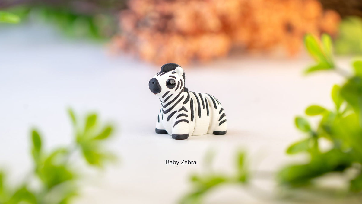 Zebra figurine with greenery in the background