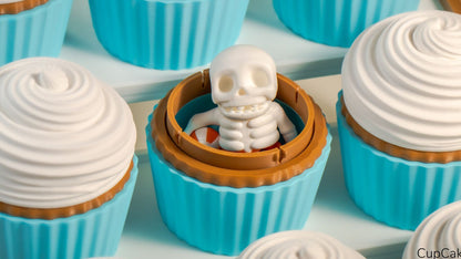 Cupcake Containers with blue cases and cream tops, one holding a tiny skeleton