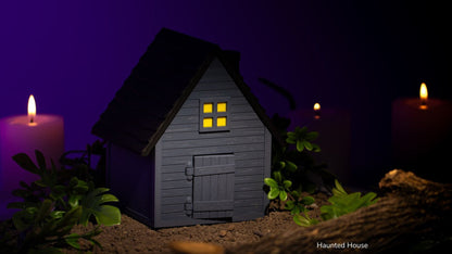 Grey Haunted House with lit windows and purple candles