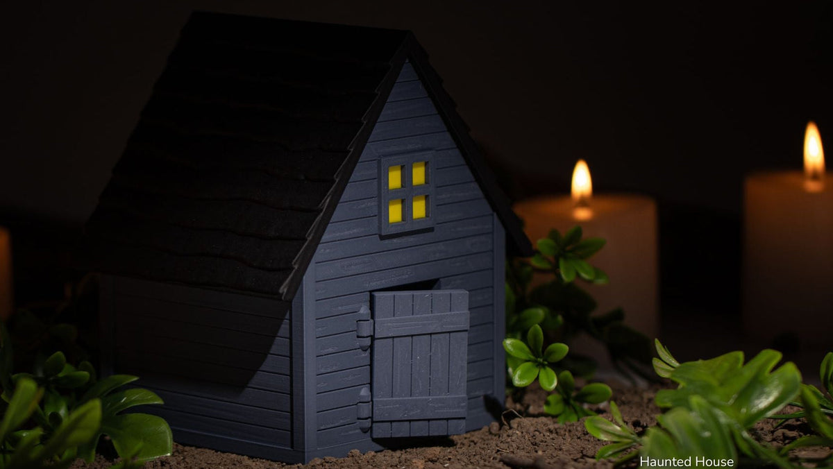 Haunted House glowing in the dark beside candles