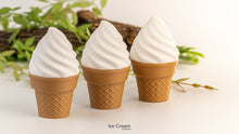 Three ice cream cones with white toppings on a light background