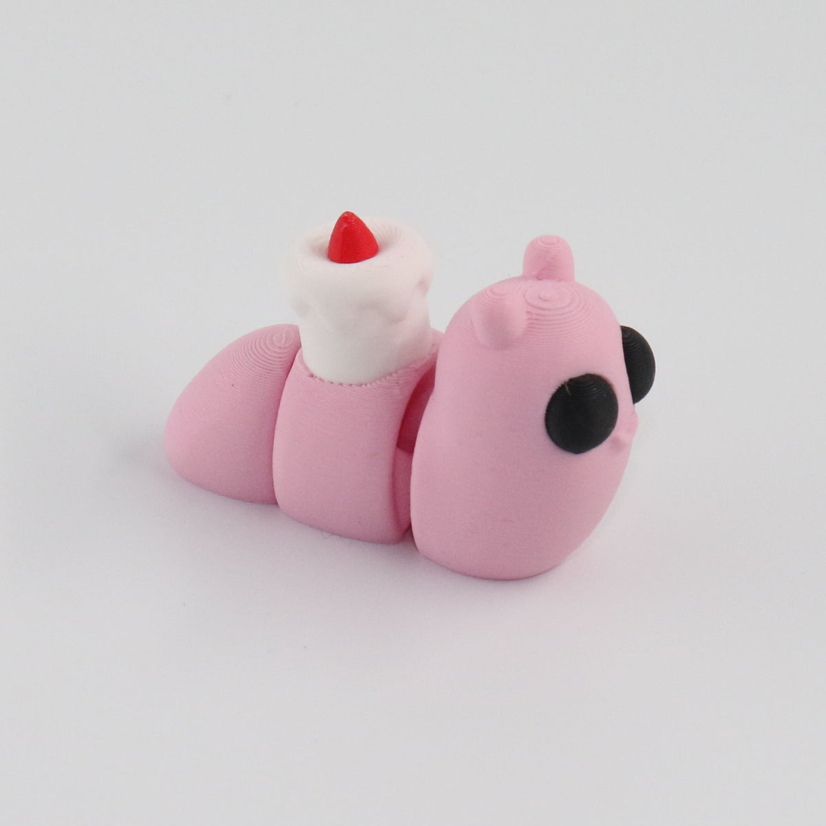Small pink snail toy figure on a light gray background