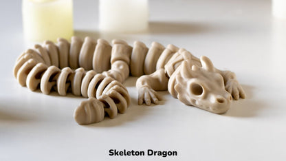 Model of a skeleton dragon on a white surface with candles in the background