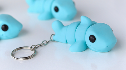 Blue shark-shaped keychain on a white background