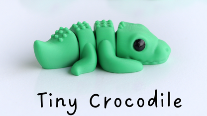 Three green crocodile figurines on a white background with 'Tiny Crocodile' text.
