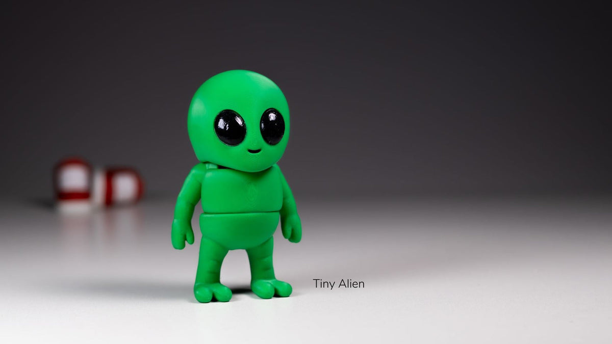 Green Tiny Alien figure with big black eyes