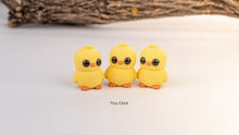 Three yellow Tiny Chick fidget toys under a wooden branch