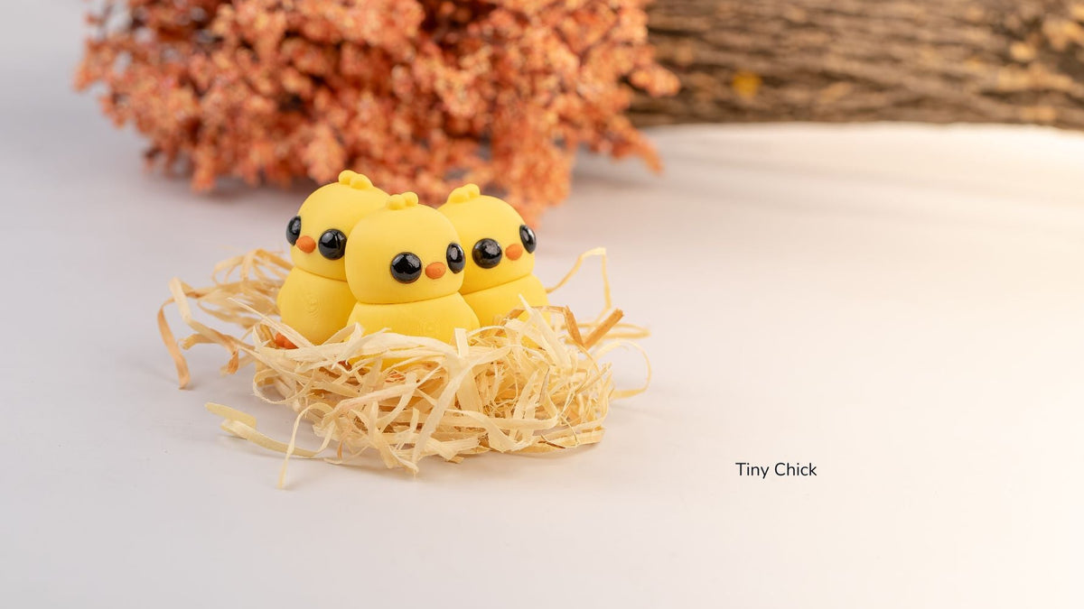 Three yellow Tiny Chicks sitting in a straw nest