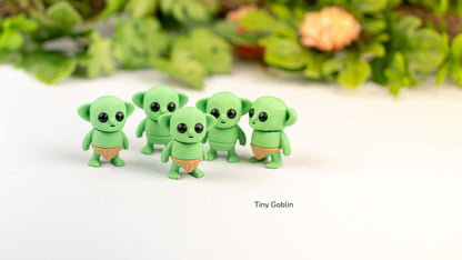 Five green Tiny Goblins with greenery behind