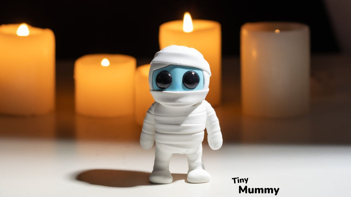 White Tiny Mummy figure with candles behind
