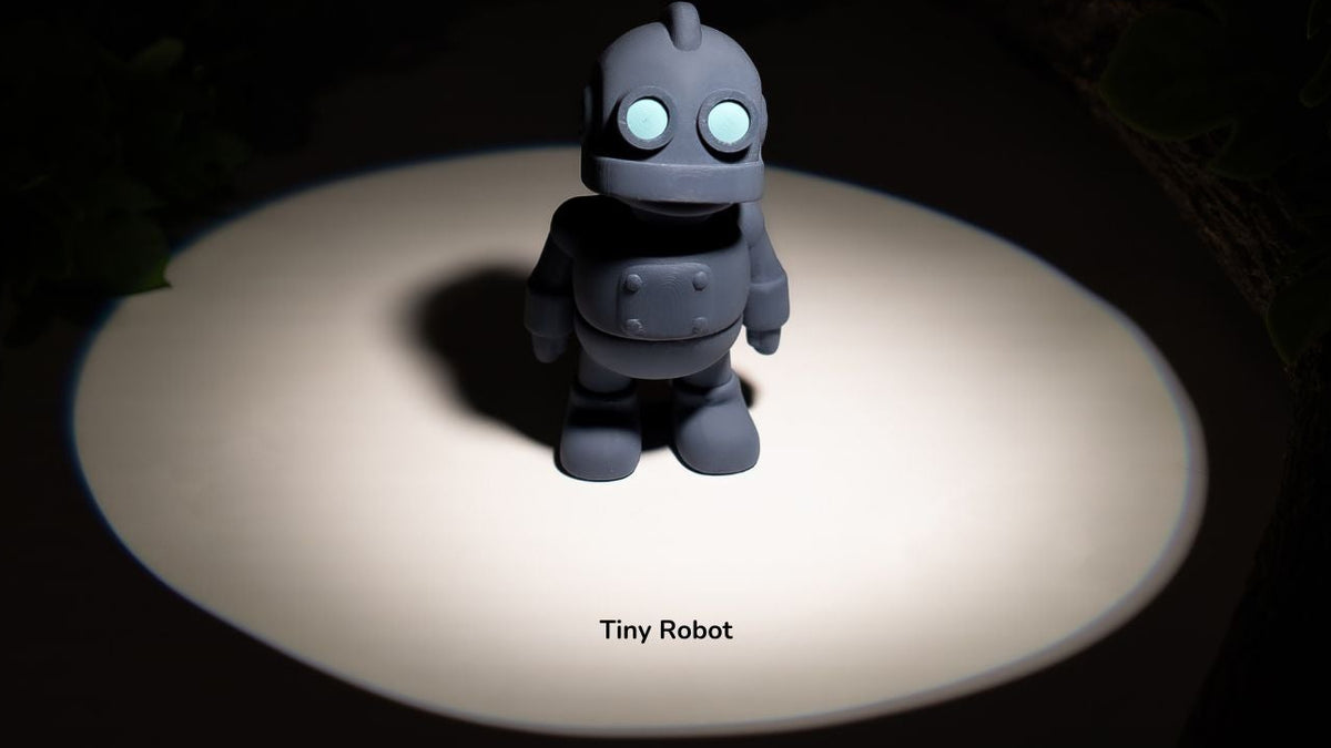 Small robot toy on a dark background with a spotlight