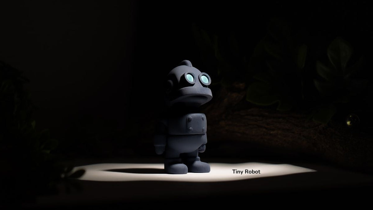 Small robot toy on a dark background with 'Tiny Robot' text