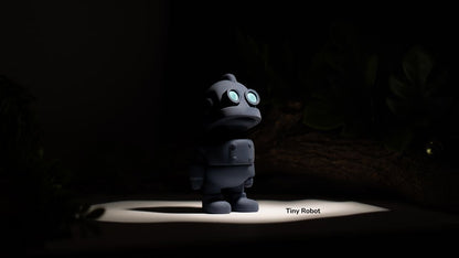 Small robot toy on a dark background with 'Tiny Robot' text