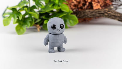 Grey Tiny Rock Golem fidget toy with plants behind