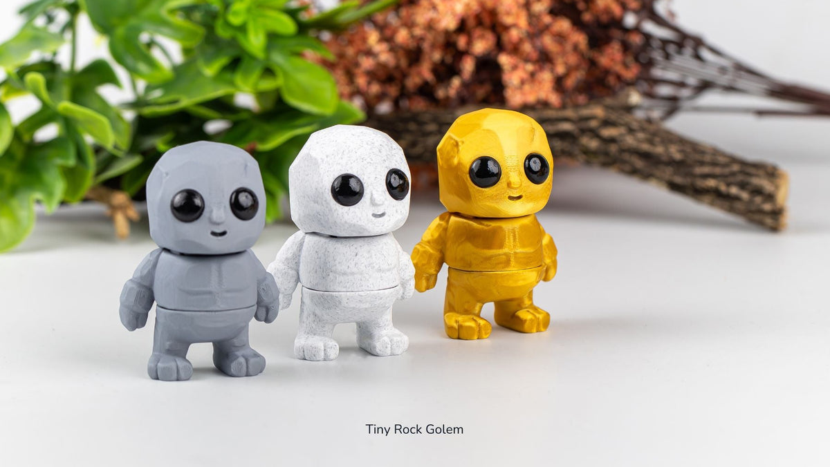 Grey, white and yellow Tiny Rock Golems in front of plants