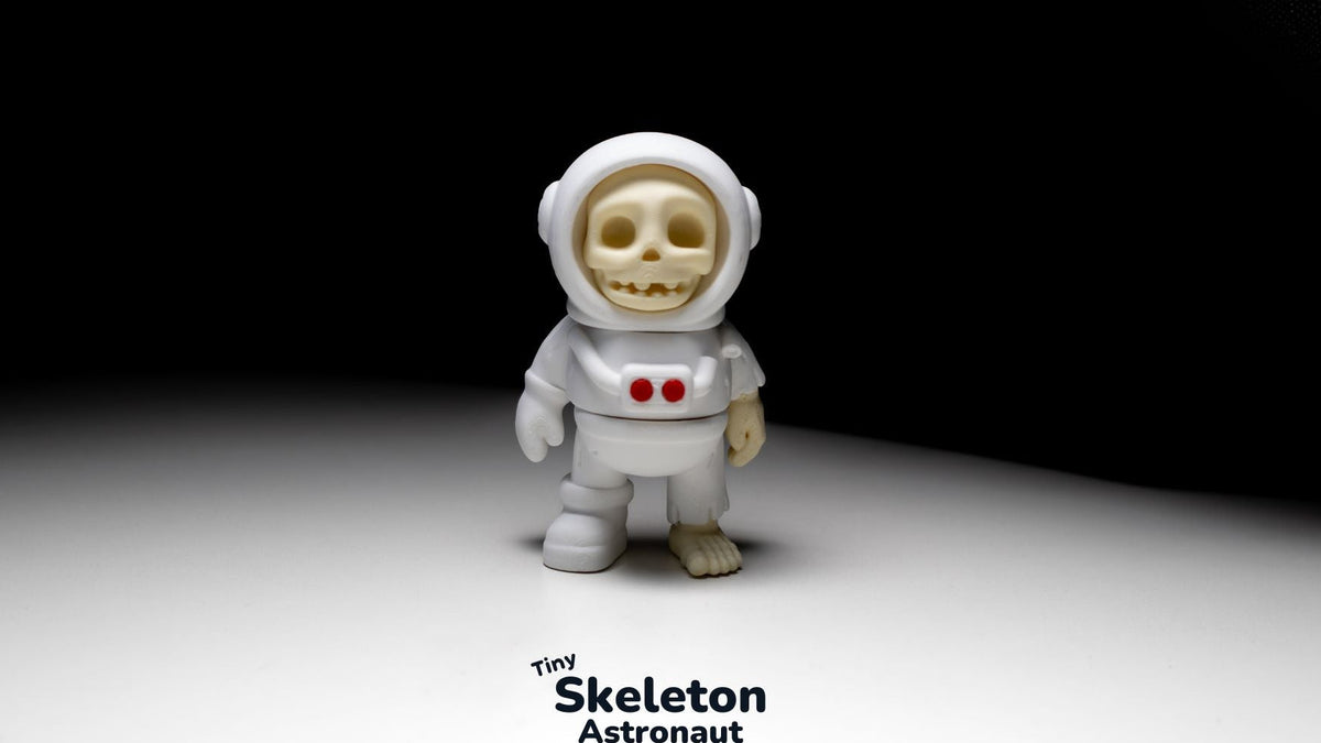 Tiny Skeleton Astronaut in a white space suit on a dark background