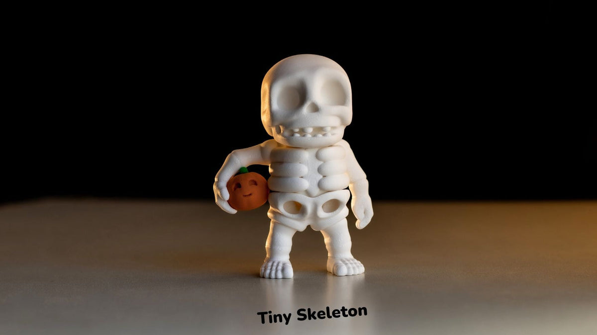 White skeleton figurine with a smaller figure inside on a dark background