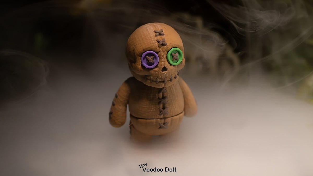 Brown Tiny Voodoo Doll with purple and green button eyes