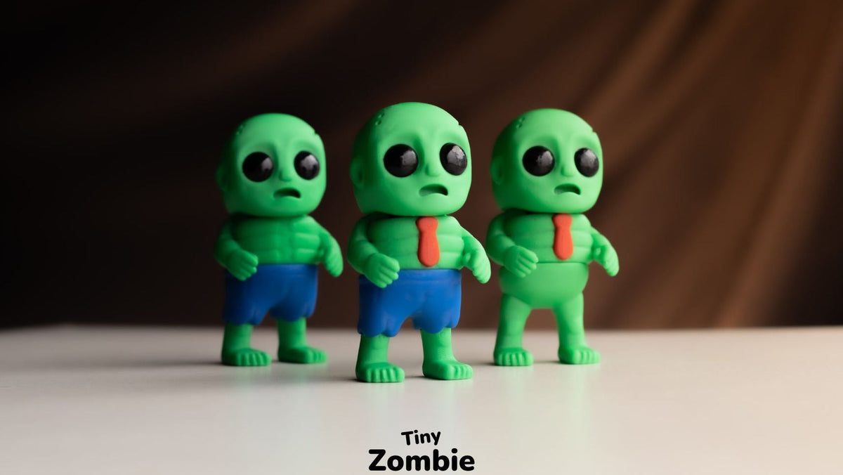 Three green Tiny Zombies in blue clothes on a dark background