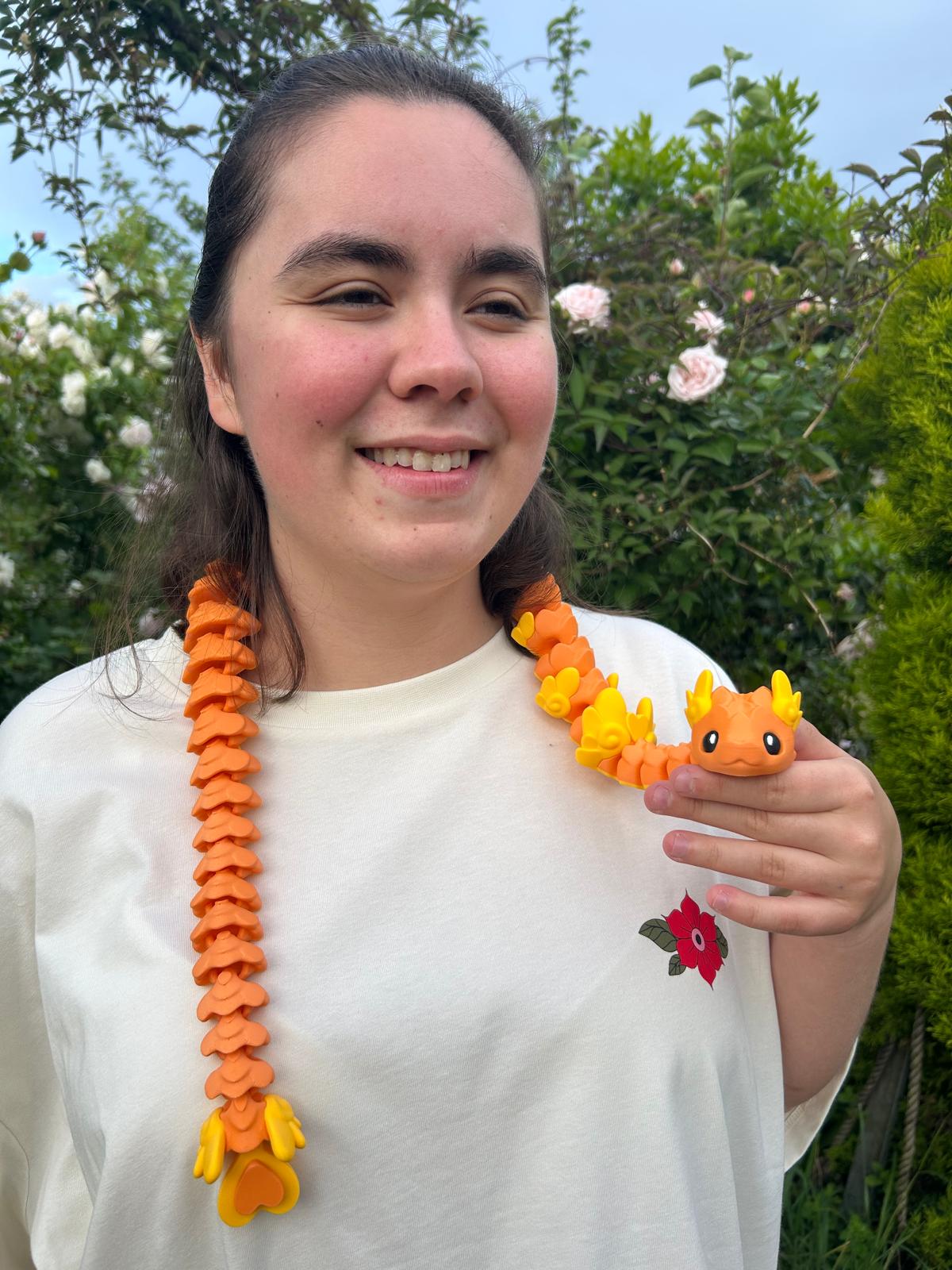 Person holding an orange Cupid Snake around their shoulders