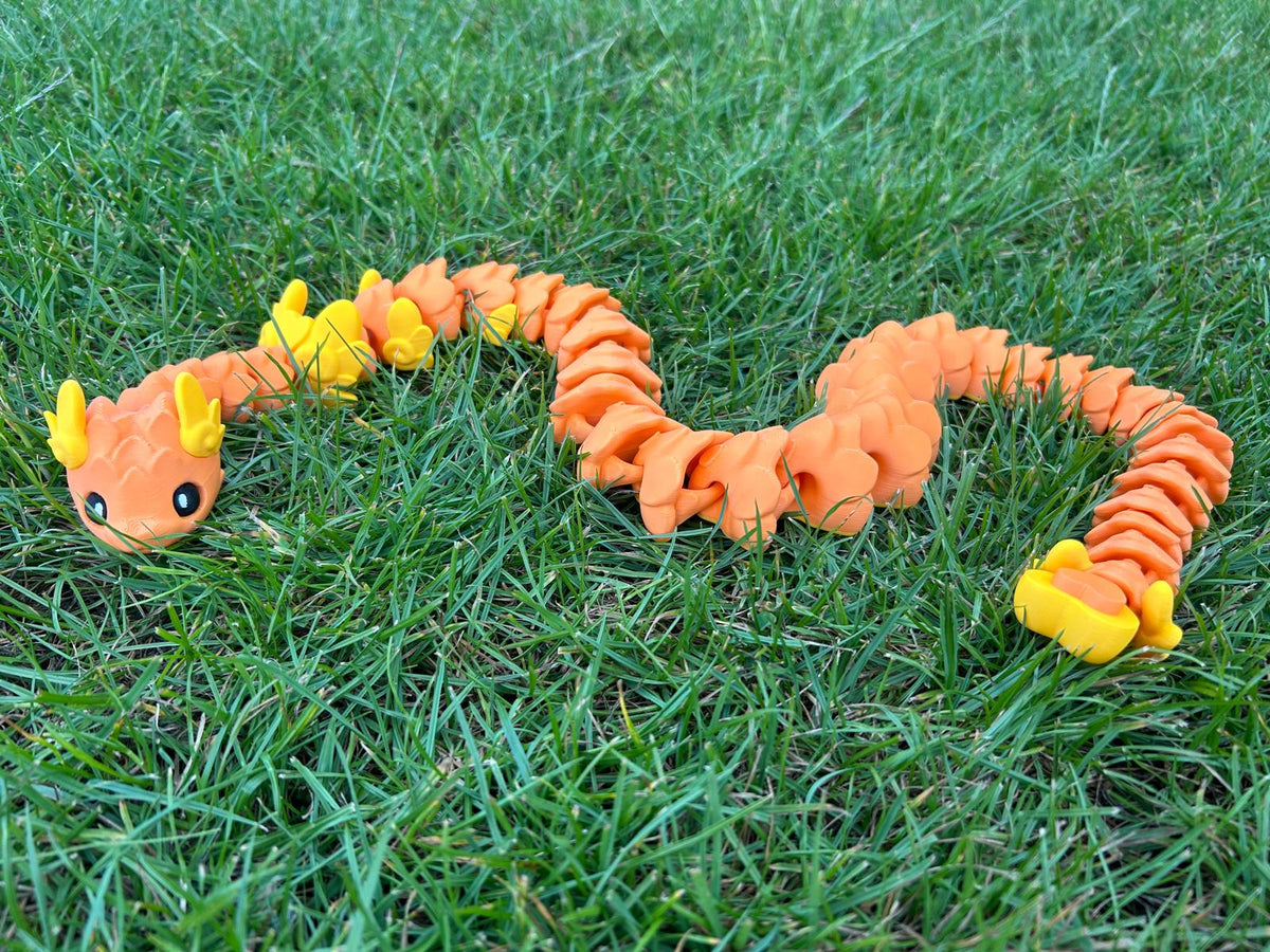 Orange Cupid Snake with heart-shaped segments on green grass